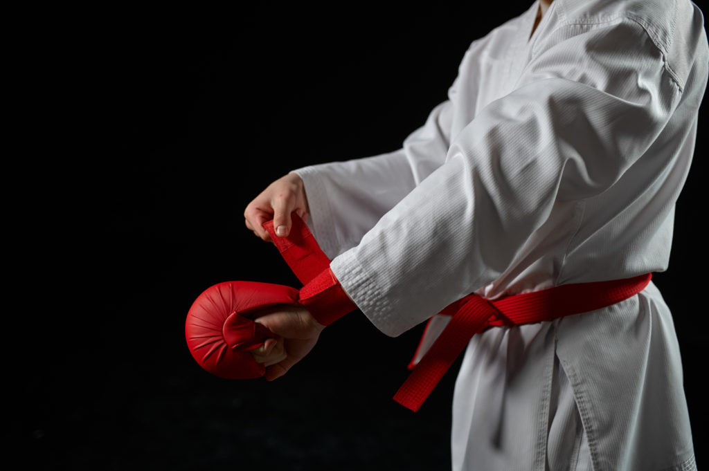 Male karate fighter having red belt and gloves
