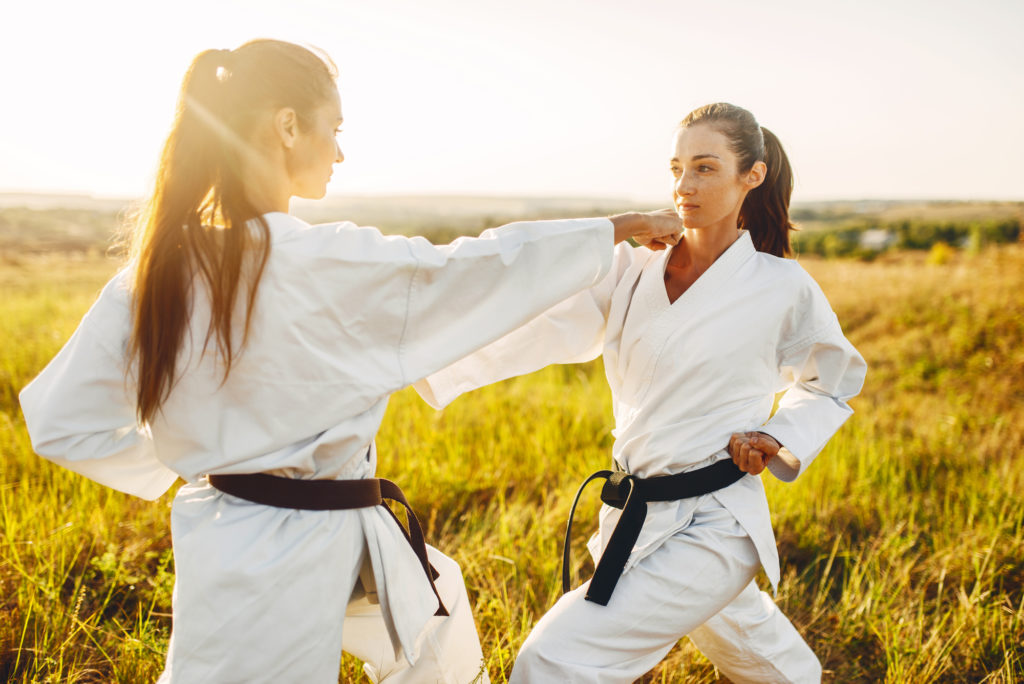 Two female karate with black belts fight